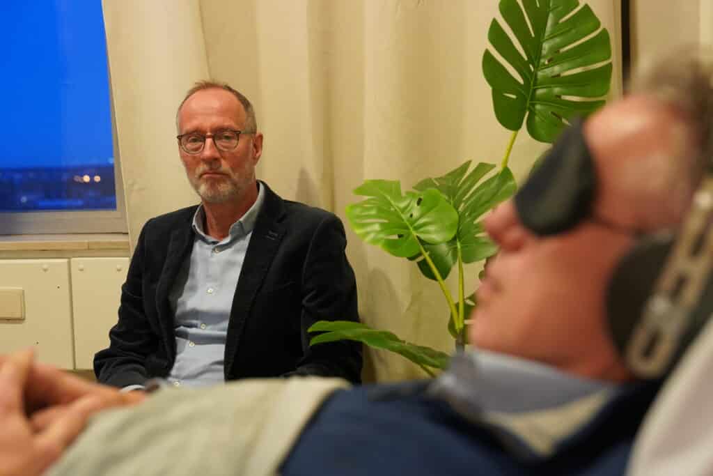 Principal investigator Robert Schoevers (UMCG) attends a patient receiving psychedelic-assisted therapy. Credits: University Medical Centre Groningen